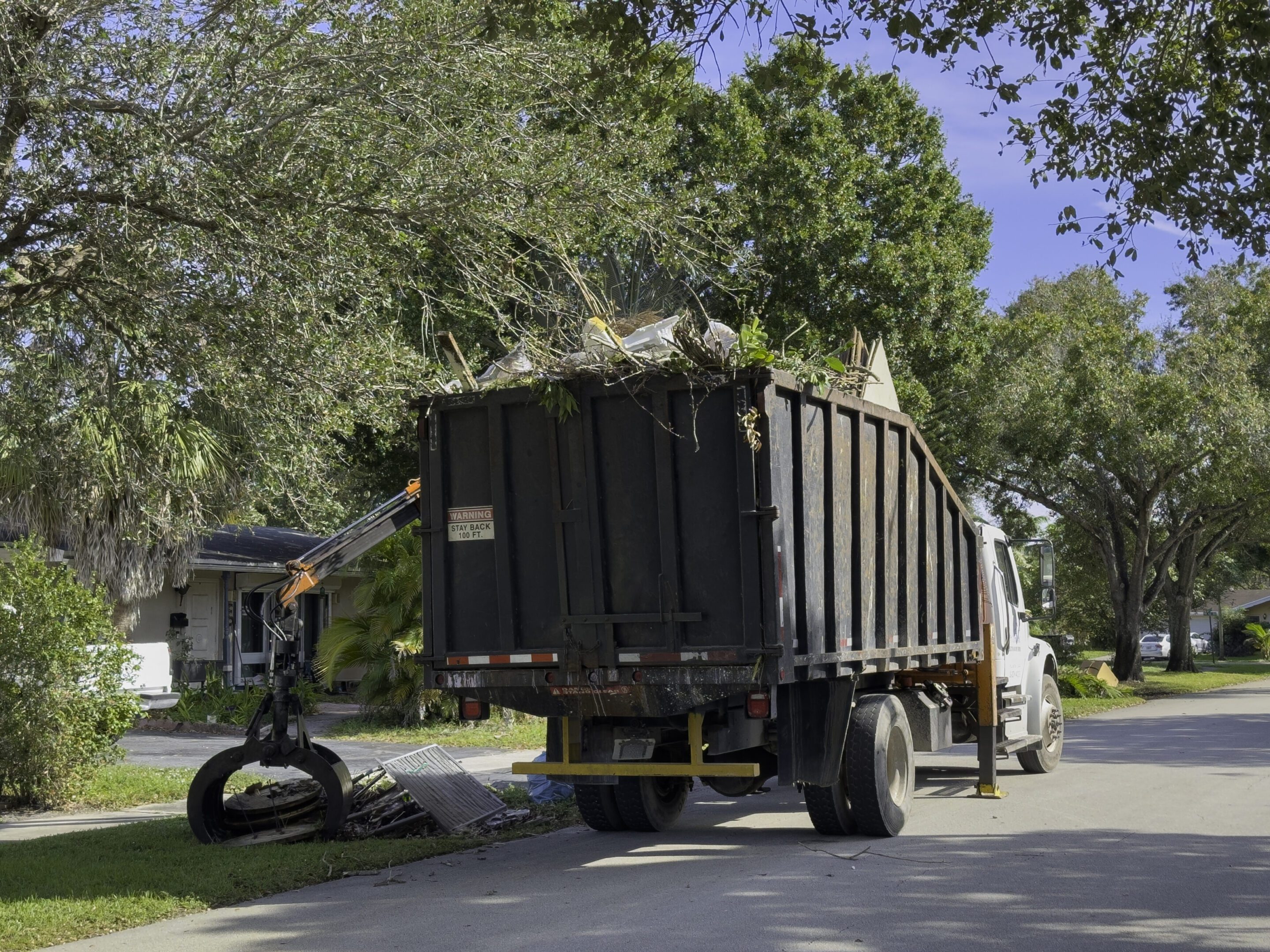 Bulk truck picking up trash in a community street, Plantation, Florida, USA